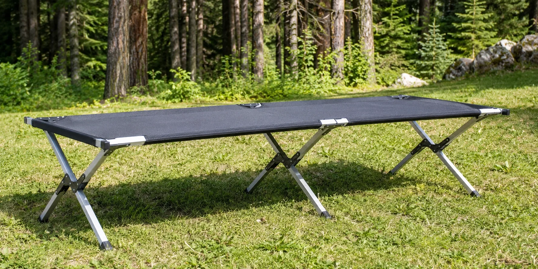 Standard folding camping cot with aluminum frame set up outdoors
